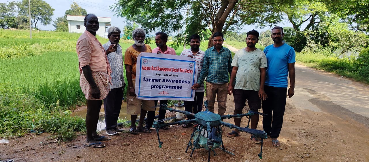 Farmers with an agricultural spray drone at a field demonstration